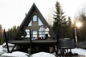 famiglia con Due figlie su terrazza via griglia minuscolo Casa nel il montagne. foto