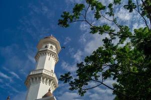 minareto kapitan keling moschea con verde albero foto