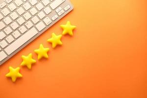 concetto di recensione del cliente con valutazione a cinque stelle su sfondo arancione foto