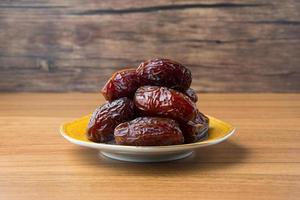 delizioso medjool date kurma o dolce secco date su un' piatto, con alcuni caduta a partire dal il piatto, come un' pasto per rottura il veloce, Ramadan kareem, vuoto spazio, copia spazio. foto