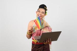 giovane bellissimo donna vestito su nel hai nord-est regione Tenere arcobaleno bandiera e il computer portatile computer foto