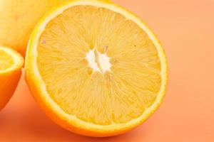 Close up di fetta di frutta arancione su sfondo arancione foto