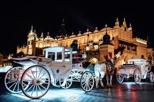 cracovia, polonia 2017 - la vecchia piazza della notte a cracovia con carrozze trainate da cavalli foto