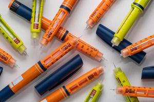 pila di iniettori di insulina usati o siringhe del tipo a penna foto
