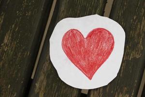 rosso cuore fatto di carta su un' di legno sfondo. foto