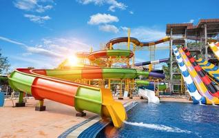 nuoto piscina con acqua scivoli nel acqua parco su soleggiato giorno. estate divertimento attività, vacanza tempo libero concetto. foto