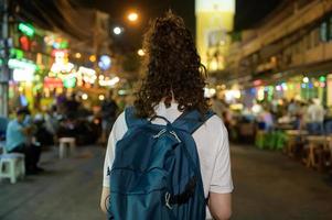 bellissimo giovane asiatico turista donna su vacanza giro turistico e esplorando a khao san strada a notte nel bangkok città, Tailandia, vacanze e in viaggio concetto foto