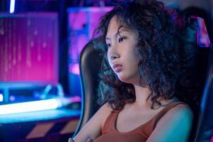 un asiatico donna programmatore è Lavorando nel sua computer camera , futuristico tecnologia concetto foto