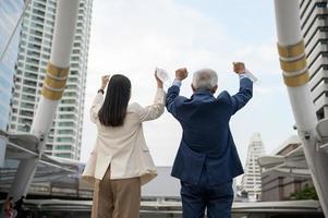 asiatico anziano maturo mezzo anziano uomo d'affari e giovane donna d'affari assunzione maschera via nel moderno città foto