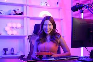 giovane asiatico bella donna professionista gamer avere vivere streaming , cantando e chat con sua fan a casa foto