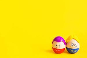 due uova divertenti ragazzo e ragazza con facce su sfondo giallo - Pasqua, primavera. giocattoli per bambini: un simbolo di una coppia di uomini e donne, amore, famiglia. copia spazio foto