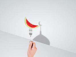 foto mano Tenere forchetta con Luna forma anguria contento Ramadan contento eid concetto. musulmano santo mese Ramadan kareem