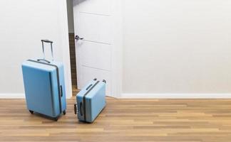 valigie blu davanti a una porta aperta foto