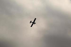 piccolo aereo volante nel il cielo contro buio nuvole foto