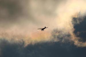 piccolo aereo volante nel il cielo contro buio nuvole foto