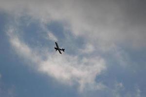 piccolo aereo volante nel il cielo contro buio nuvole foto