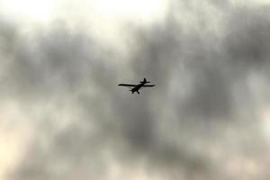 piccolo aereo volante nel il cielo contro buio nuvole foto