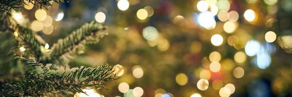 Natale albero coperto neve con giallo ghirlande luci e bokeh copia spazio con scintillò luci foto