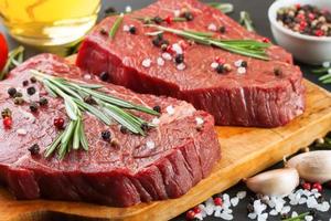 fresco crudo Manzo bistecca con Spezia su nero ardesia sfondo foto