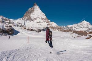 giovane uomo snowboard nel Zermatt sciare ricorrere giusto Il prossimo per il famoso Cervino picco. bellissimo soleggiato giorno per lo snowboard. inverno gli sport concetto. foto