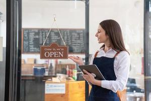 ritratto di un' donna, un' caffè negozio attività commerciale proprietario sorridente meravigliosamente e apertura un' caffè negozio quello è sua proprio attività commerciale, piccolo attività commerciale concetto. foto