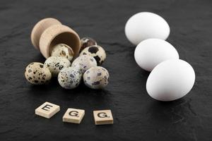 quaglia e uova di gallina su uno sfondo nero foto