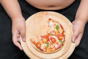 Pizza su legna piatto con obeso Grasso ragazzo sfondo foto