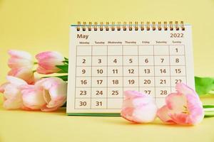 calendario e fiori vicino su foto