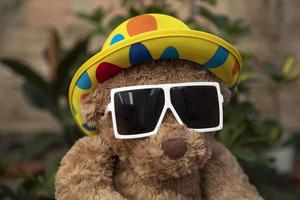 orsacchiotto orso con occhiali da sole nel un' giardino foto