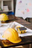 costruzione e struttura concetto di ingegnere o architetto incontro per progetto Lavorando con compagno e ingegneria utensili su modello edificio e planimetria nel Lavorando luogo, contrarre per tutti e due aziende. foto