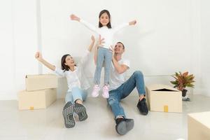 contento famiglia con ragazza in movimento in un' nuovo casa. foto