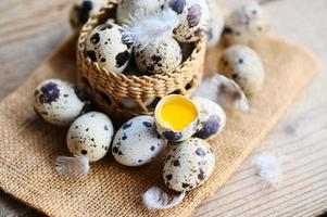 Quaglia uova su cestino, fresco Quaglia uova su di legno tavolo sfondo, crudo uova con sbucciare uovo conchiglia foto