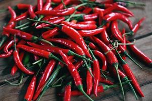 chili Pepe, rosso caldo peperoncino peperoni su di legno sfondo. vicino su gruppo di maturo rosso peperoncino foto