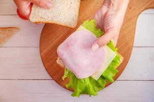 la mamma prepara un panino per il pranzo scolastico foto