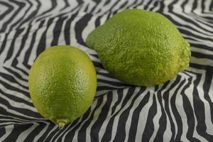 limoni verdi su una tovaglia foto