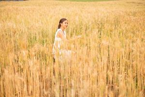 giovane asiatico donne nel bianca vestiti nel il orzo riso campo foto