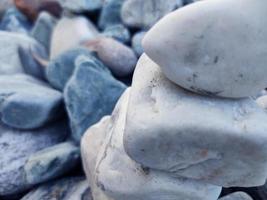 pila di triangolare pietre.gruppo di bianca e colorato pietre.pebble Torre su il pietre mare.pietre piramide su ciottolo spiaggia simboleggiante stabilità,zen,rock,armonia,equilibrio.shallow profondità di campo. foto