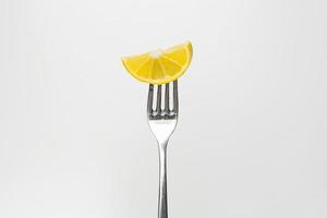 foto di un' fresco Limone fetta su un' forchetta isolato su un' bianca sfondo, parte di un' serie.