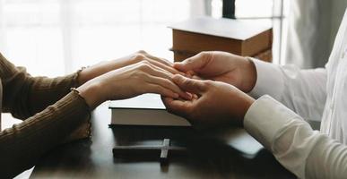 Due persone lettura e studia Bibbia nel casa e pregare insieme.studiando il parola di Dio con gli amici. foto