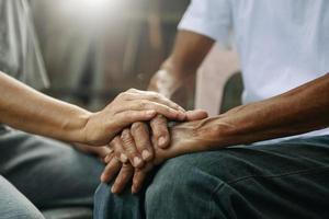 mani di il vecchio uomo e un' donna mano su il legna tavolo foto