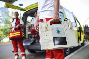 mano di il medico con defibrillatore. squadre di il emergenza medico servizio siamo rispondere per un traffico incidente. foto