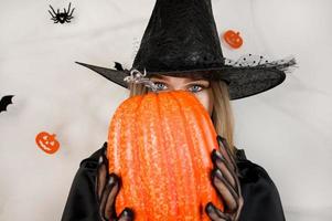 mistero Halloween sfondo con strega nascondiglio dietro a zucca. foto