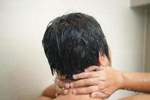 un' uomo è utilizzando doccia crema per asciutto pelle ritorna pelle per essere morbido, idratato e nutrito foto