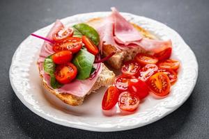 Sandwich prosciutto, pomodoro, lattuga Bruschetta merenda pronto per mangiare salutare pasto cibo merenda su il tavolo copia spazio cibo sfondo rustico superiore Visualizza foto