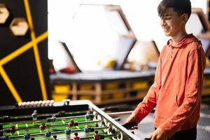 ragazzo giocando tavolo calcio nel bambini giocare centro. foto