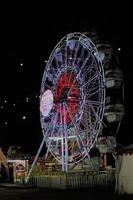 Ferris ruota a il notte mercato con colorato luci foto