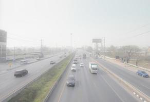 percorso di me, Thailandia-marzo 10, 2023 macchine guida su autostrada strada con aria inquinamento. smog e bene polvere di PM2.5 coperto città. inquinata aria. sporco ambiente. urbano tossico polvere. malsano aria. foto