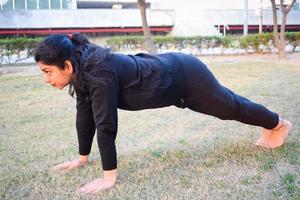 giovane indiano donna praticante yoga all'aperto nel un' parco. bellissimo ragazza pratica di base yoga posa. quiete e relax, femmina felicità. di base yoga pose all'aperto foto