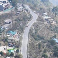 vista aerea dall'alto dei veicoli stradali che guidano su strade di montagna a nainital, india, uttarakhand, vista dal lato superiore della montagna per il movimento di veicoli stradali foto