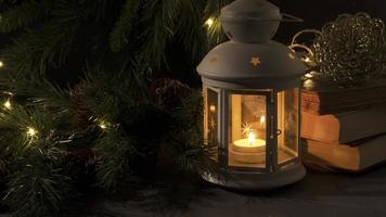 bianca lanterna con un' ardente candela. libri, Natale albero ramo e luci su sfondo. notte buio immagine. Natale mistero umore. foto